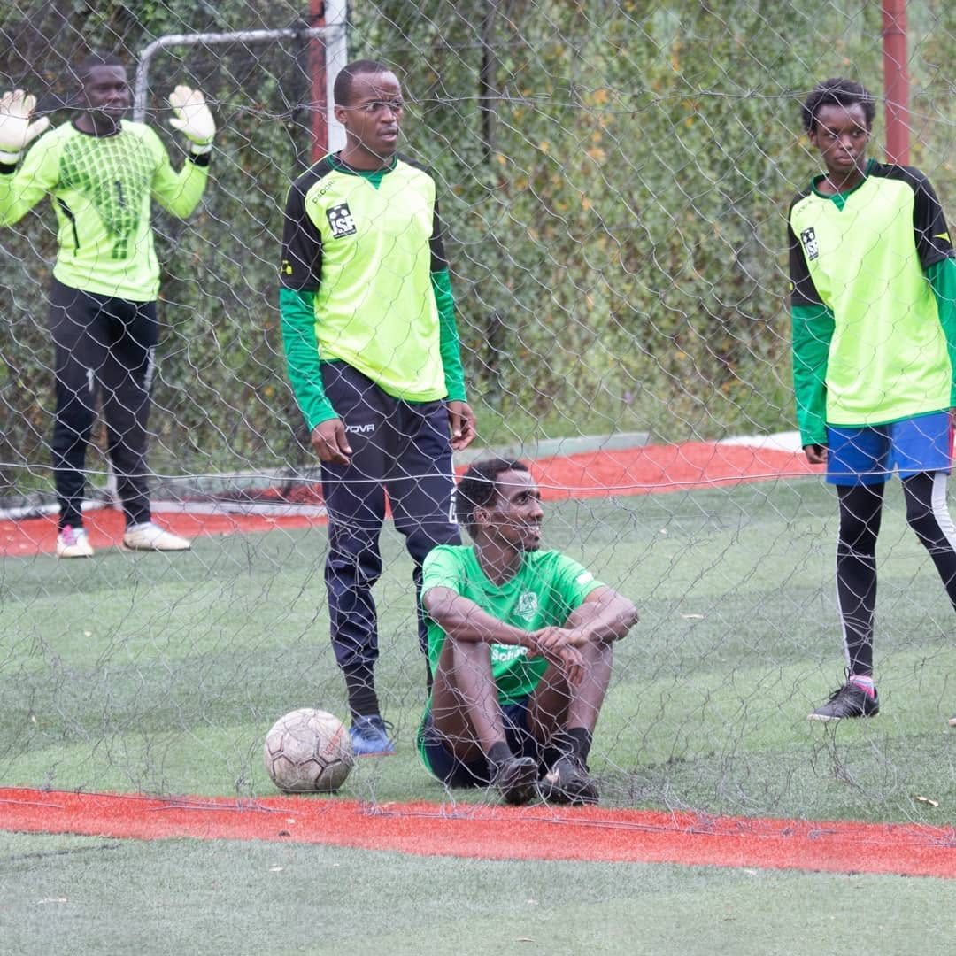 Players resting in the goal area after a match