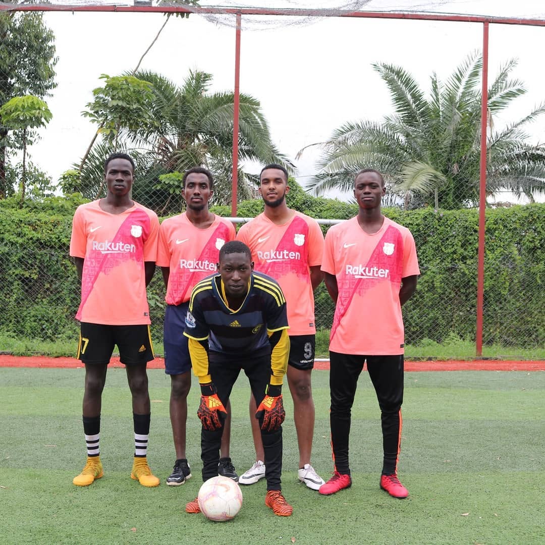 Team posing in matching pink kits with goalkeeper